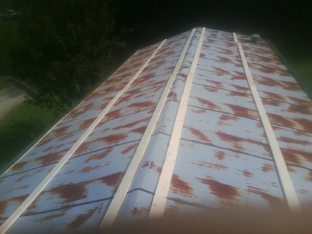 Rusted metal roof panels with new wood purlins before replacement — Storm Damage Roof Repair in Heron by Roofing Brothers